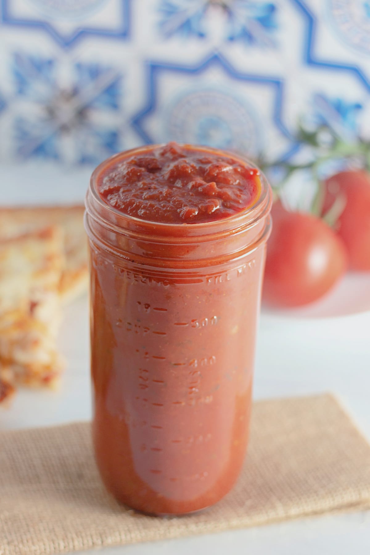 jar of homemade pizza sauce on a counter.