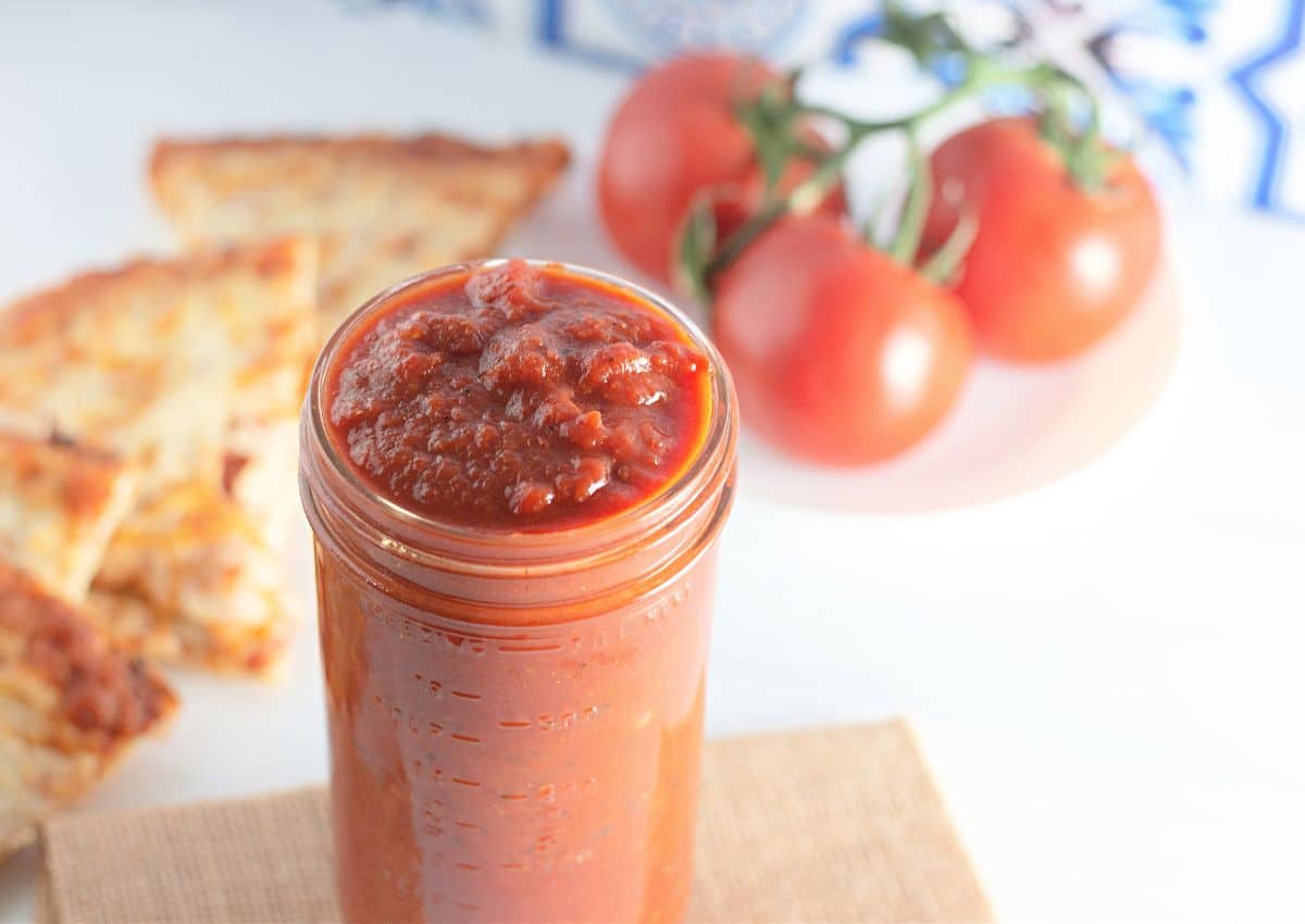 jar of homemade pizza sauce on a counter.