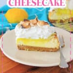 slice of lemon meringue cheesecake on a small plate with a fork.