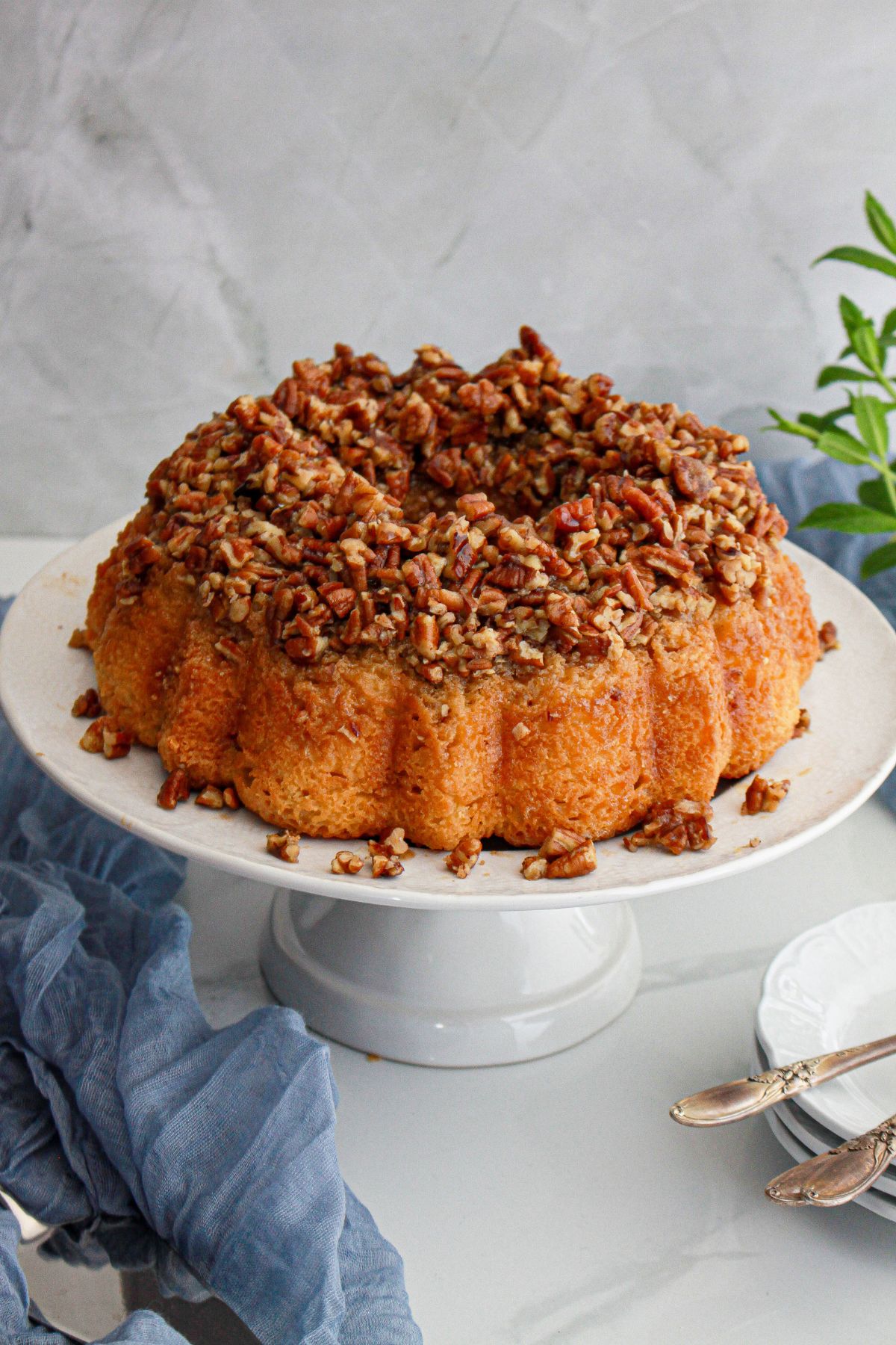 uncut pecan upside down cake on a cake stand.