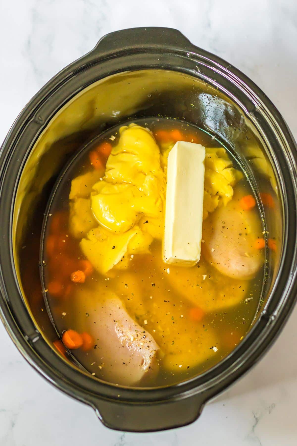 butter, chicken ,carrots, seaosning, and cream of chicken soup in the crcokpot.