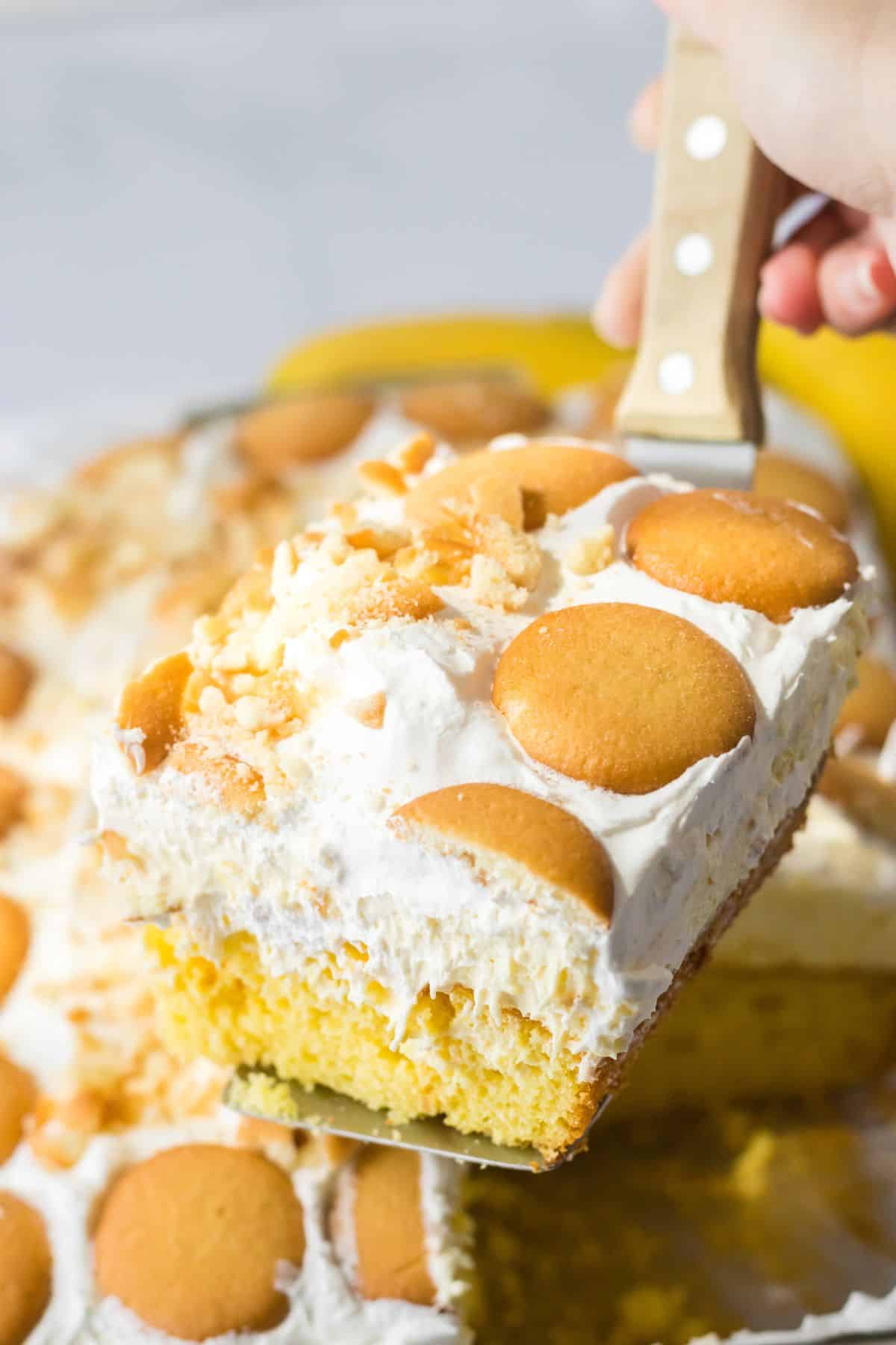 slice of banana pudding poke cake on a spatula.