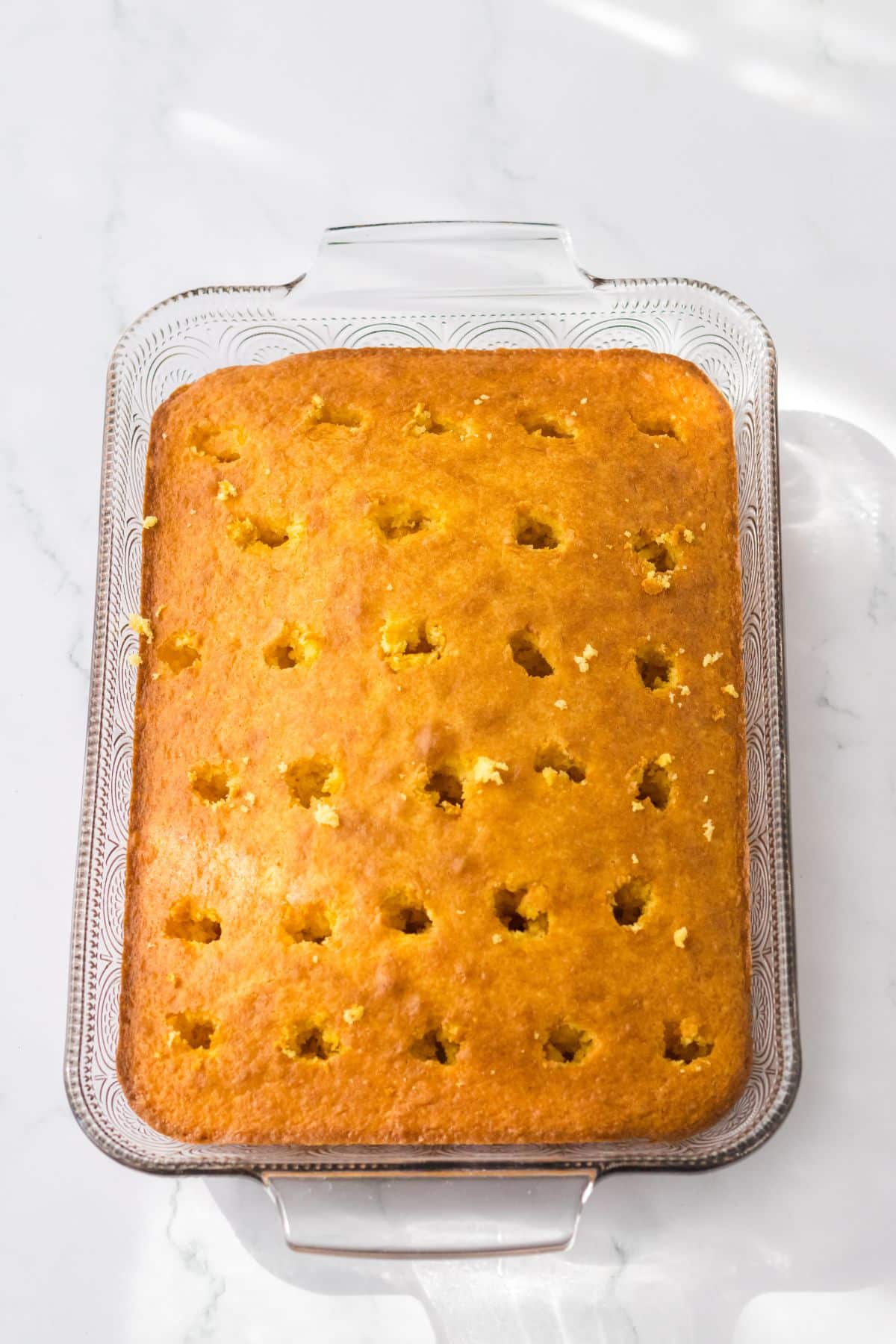 holes being poked into a glass baking dish.
