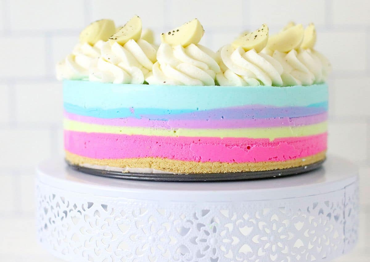 uncut birthday cake cheesecake on a cake stand.