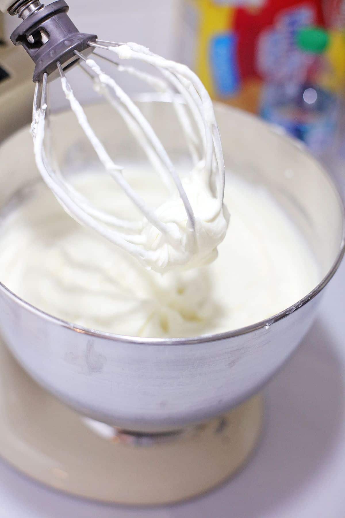 cheescake batter being mixed in a stand mixer.