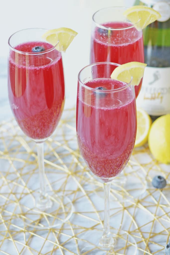 three blueberry lemon mimosas on a counter.