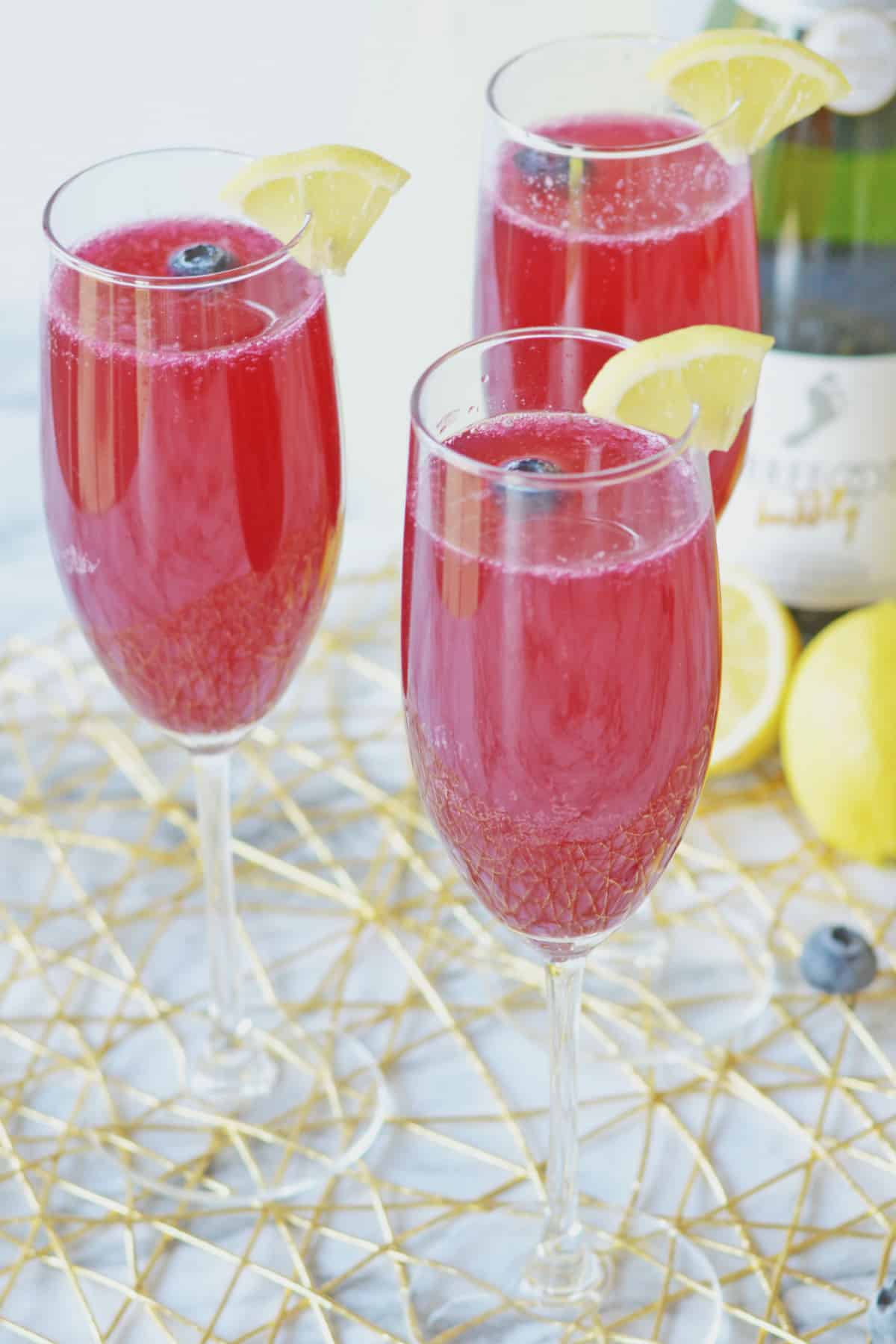 three blueberry lemon mimosas on a counter.
