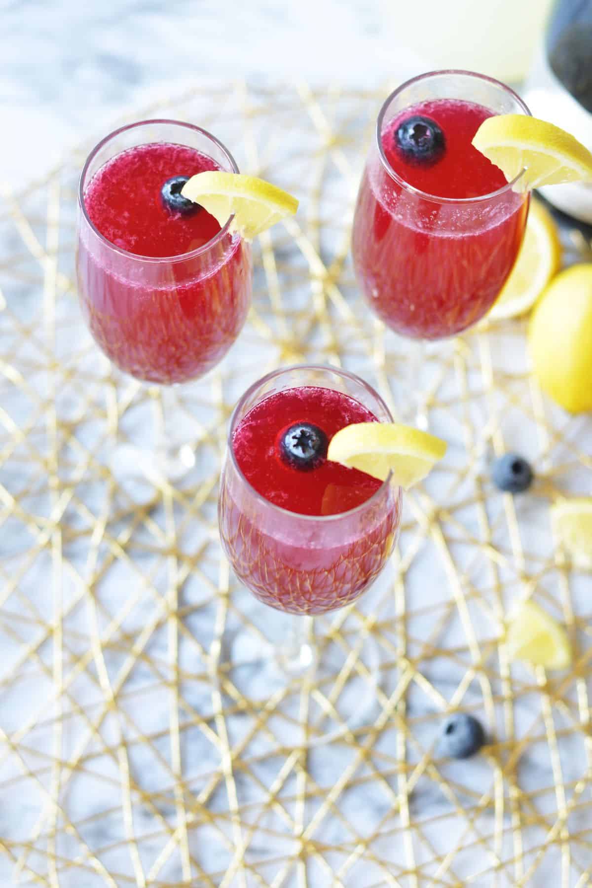 three blueberry lemon mimosas on a counter.