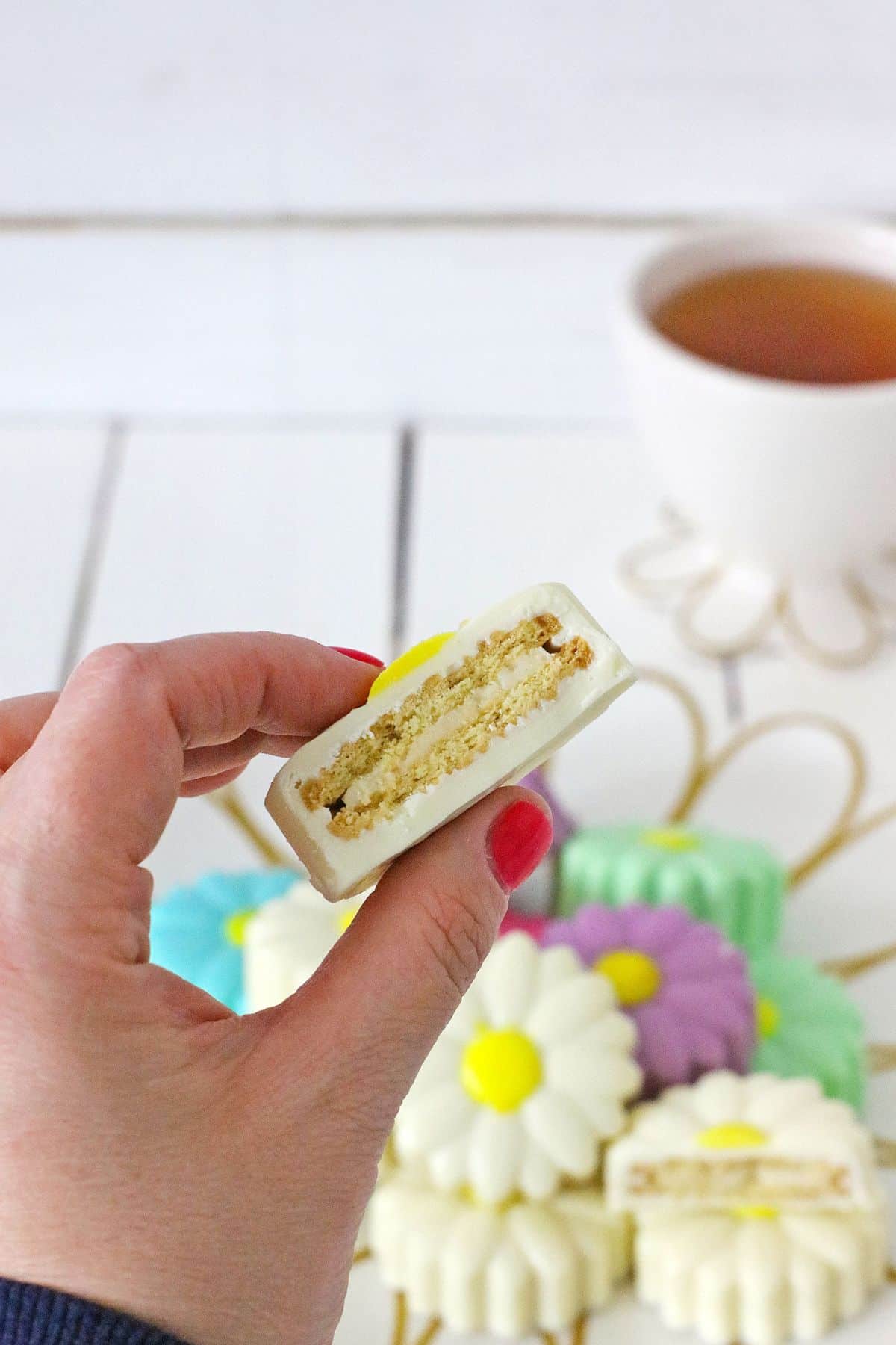 daisy white chocolate covered oreo held in the air broken in half.