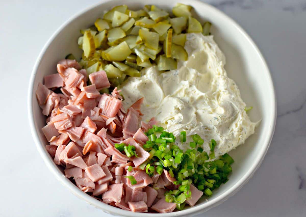cream cheese, pickles, ham, and green onions, in a bowl.