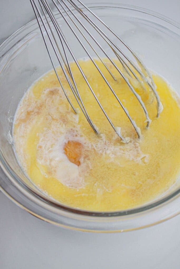 wet ingredients being mixed in a glass bowl.