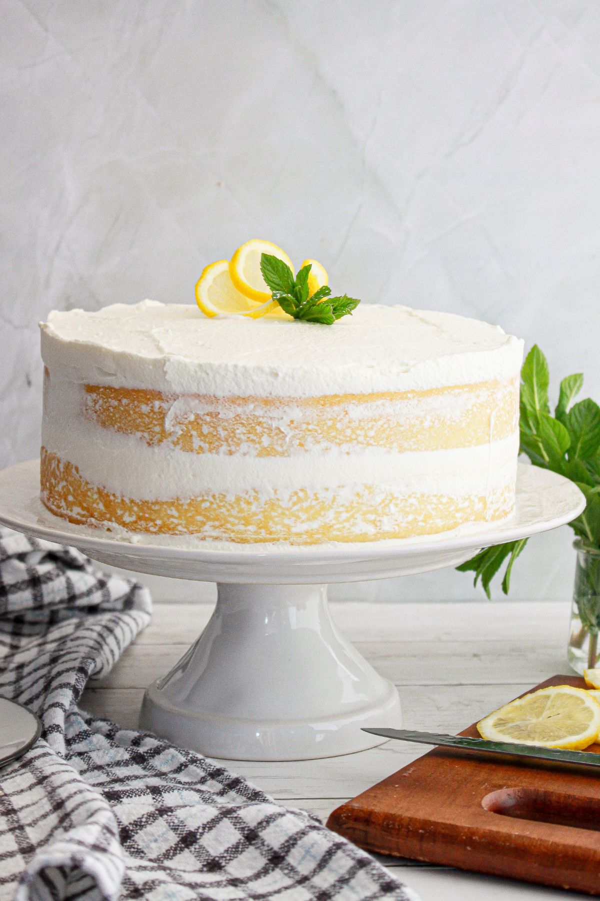 uncut italian lemon cream cake on a cake stand.