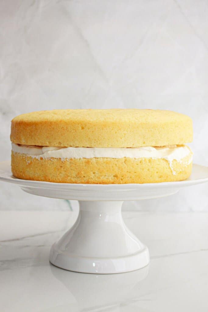 cake layers being stacked on top of each other on a cake plate.