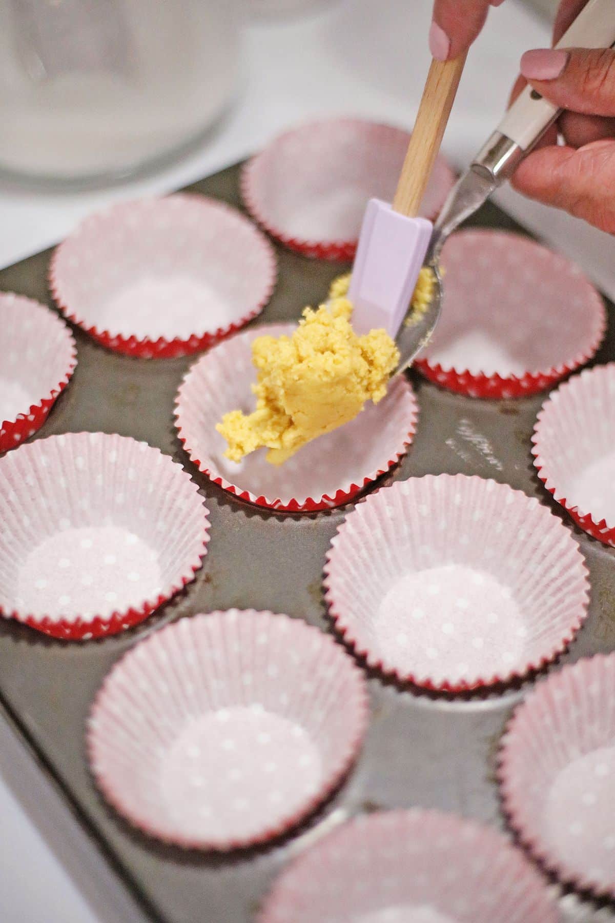 crust made with cookies being added to a muffin pan.
