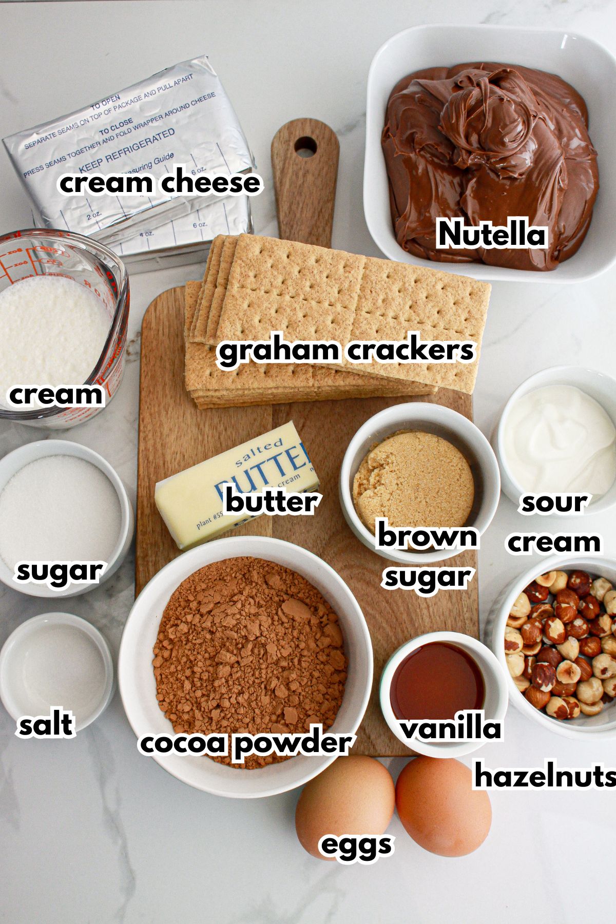 bowls of ingredients needed to make nutella cheesecake bars on a counter.