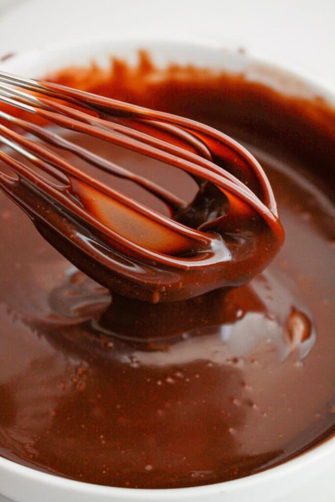 chocolate ganache being mixed in a bowl.