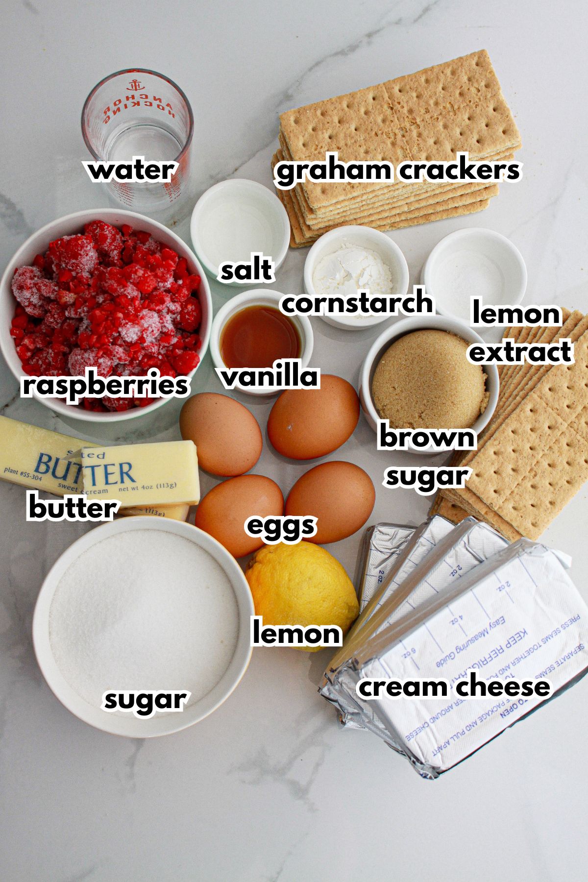 bowls of ingredients needed to make raspberry swirl cheesecake on a counter.