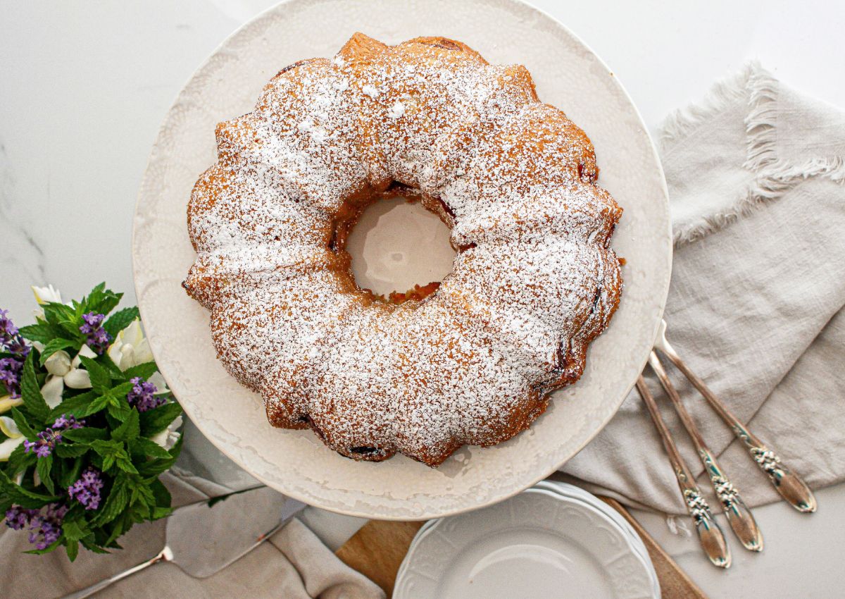 uncut rhubarb strawberry bundt cake on a cake platter.