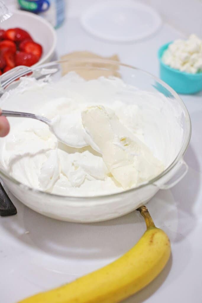cream cheese and whipped topping being added to pudding.