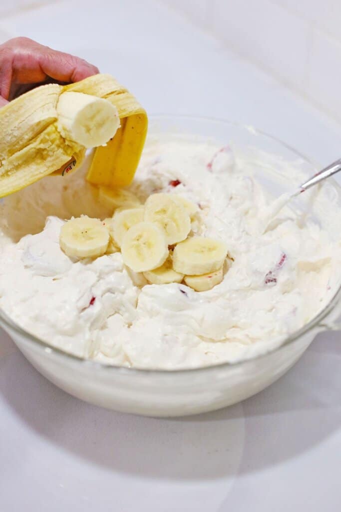 banana slices being folded into cream cheese mixture.