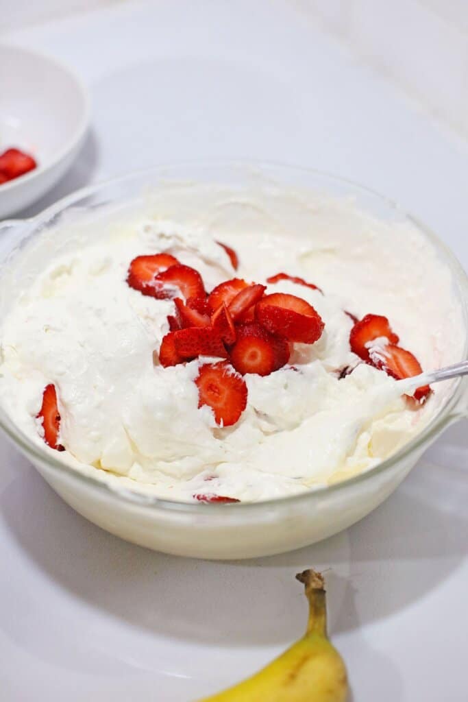strawberries being folded into cream cheese mixture.