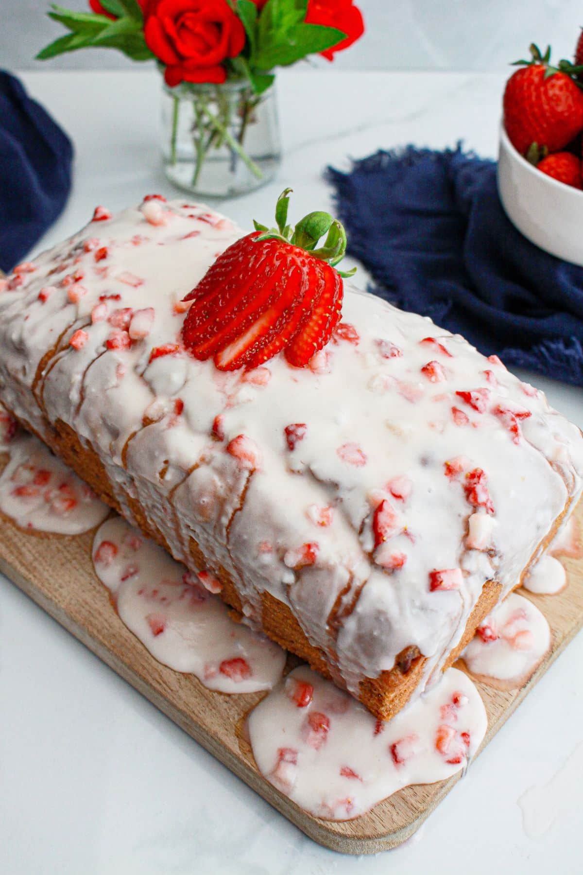 uncut strawberry bread on a cutting board.