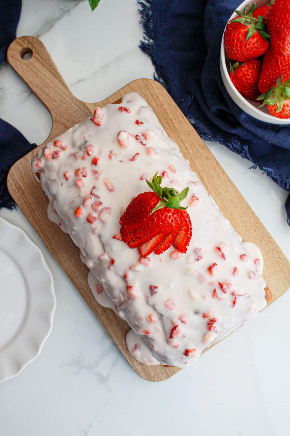 uncut strawberry bread on a cutting board.