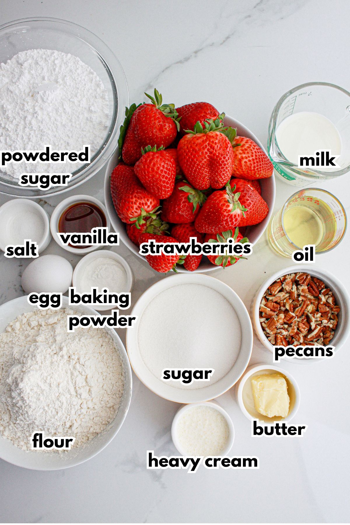 bowls of powdered sugar, salt, vanilla, egg, baking powder, flour, sugar, cream, oil, pecans, milk, and butter on a counter.