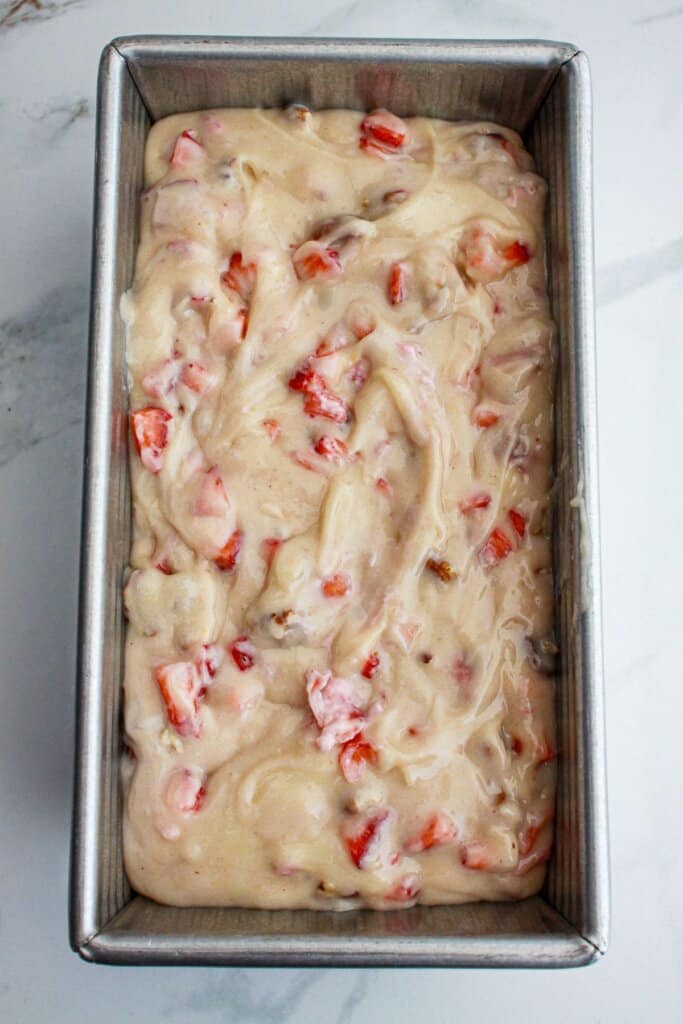 loaf cake batter poured into a loaf pan and ready for the oven.