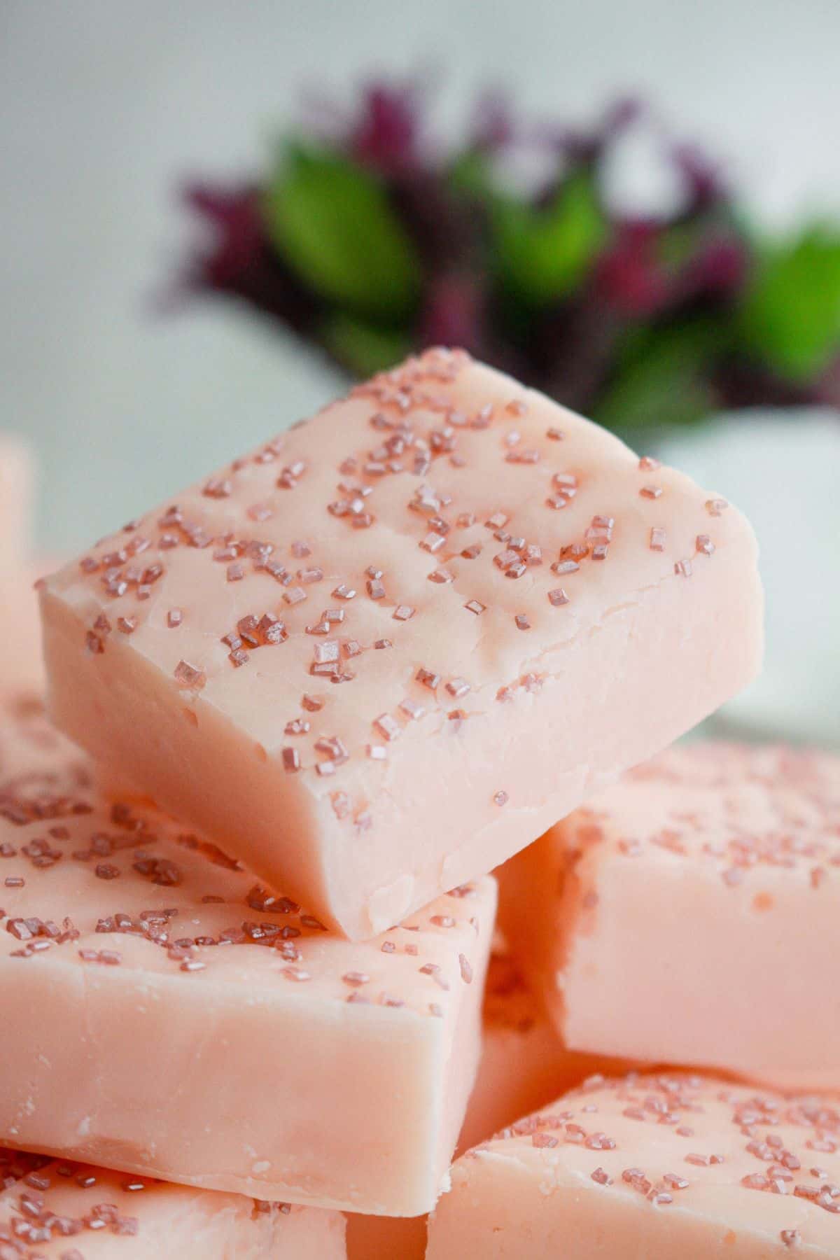 pieces of white chocolate raspberry fudge stacked in a pyramid.