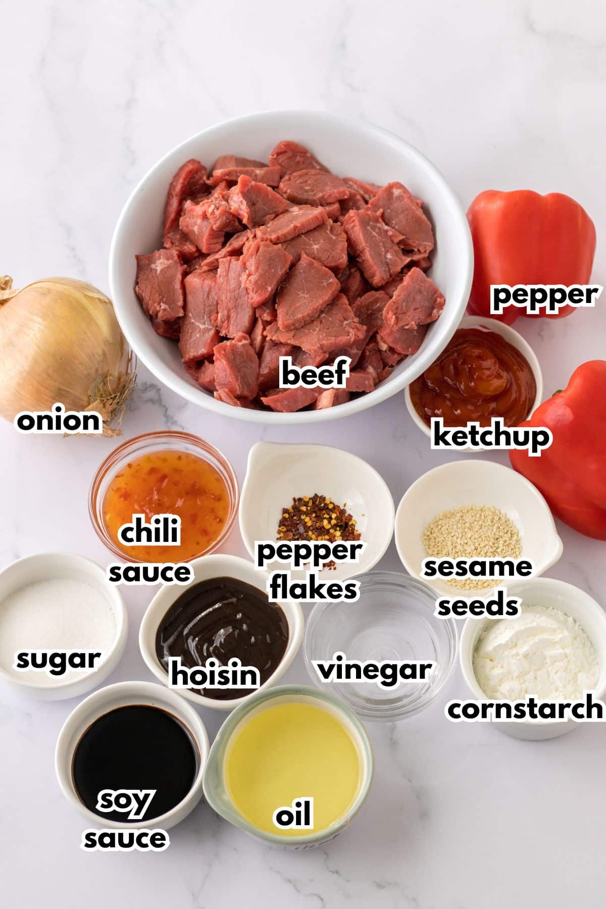 bowls of onion, beef, pepper, chili sauce, sugar, pepper flakes, hoisin, soy sauce, oil, vinegar, sesame seeds, ketchups, and cornstarch on a counter.