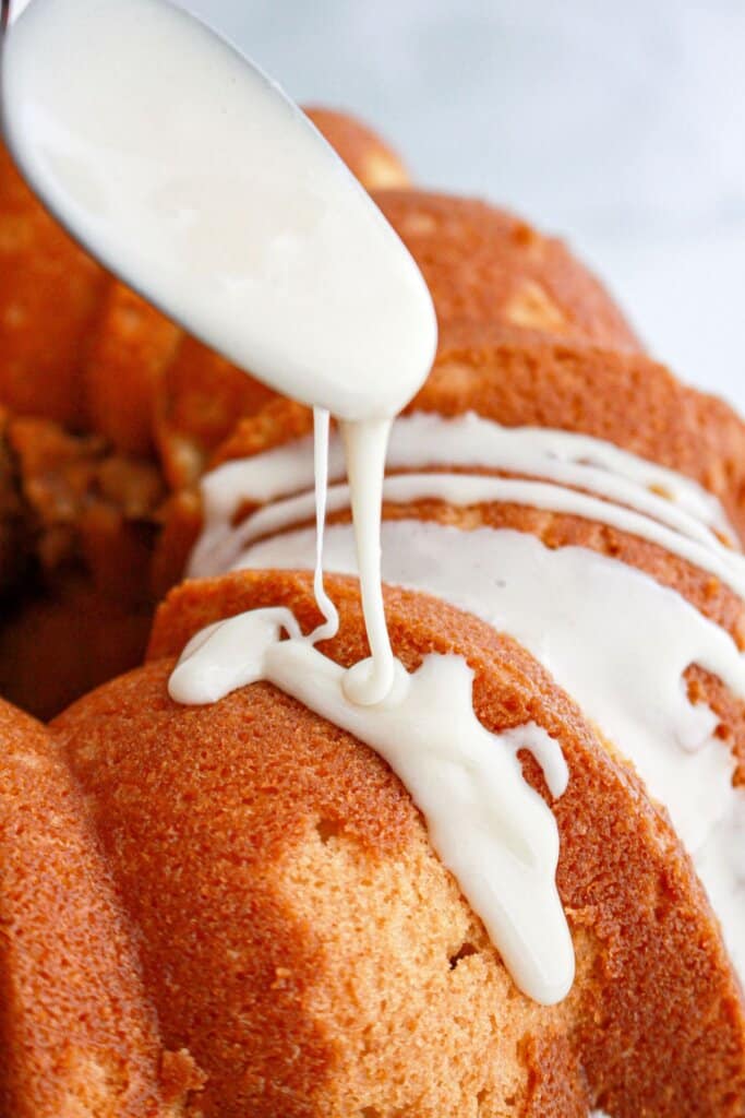 glaze being drizzled over the cake.
