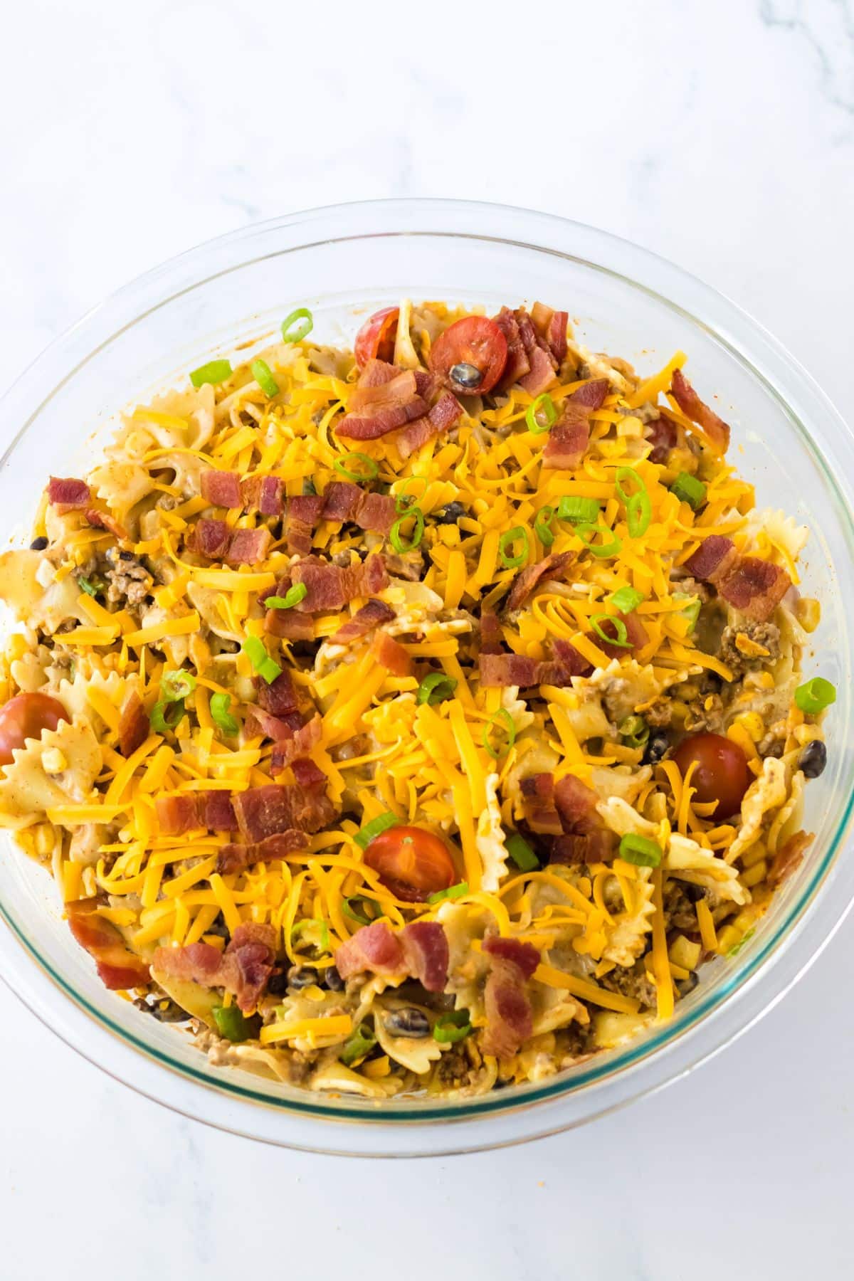 cowboy pasta salad being mixed together.