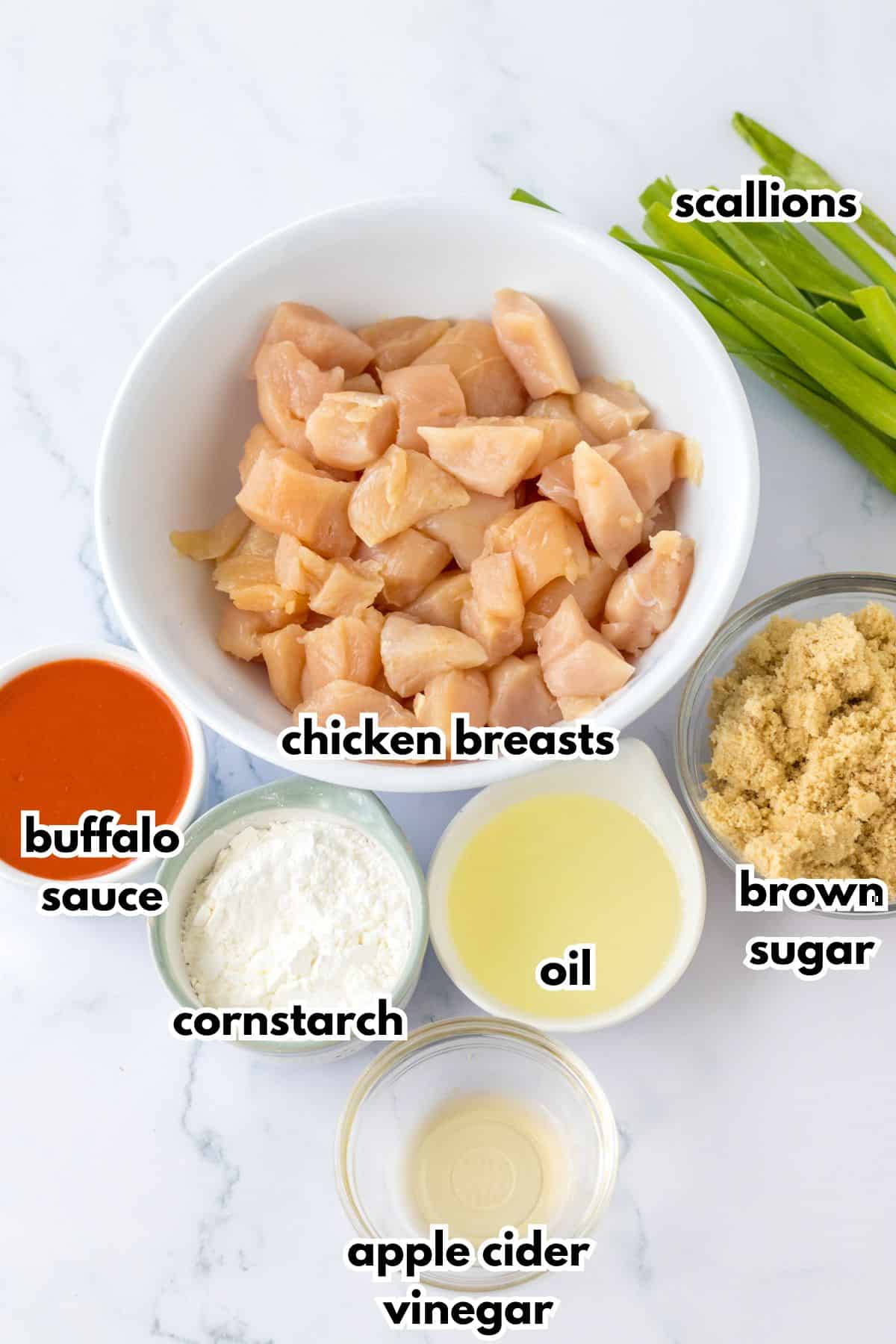 bowls of scallions, buffalo sauce, cornstarch, apple cider vinegar, oil, and brown sugar.