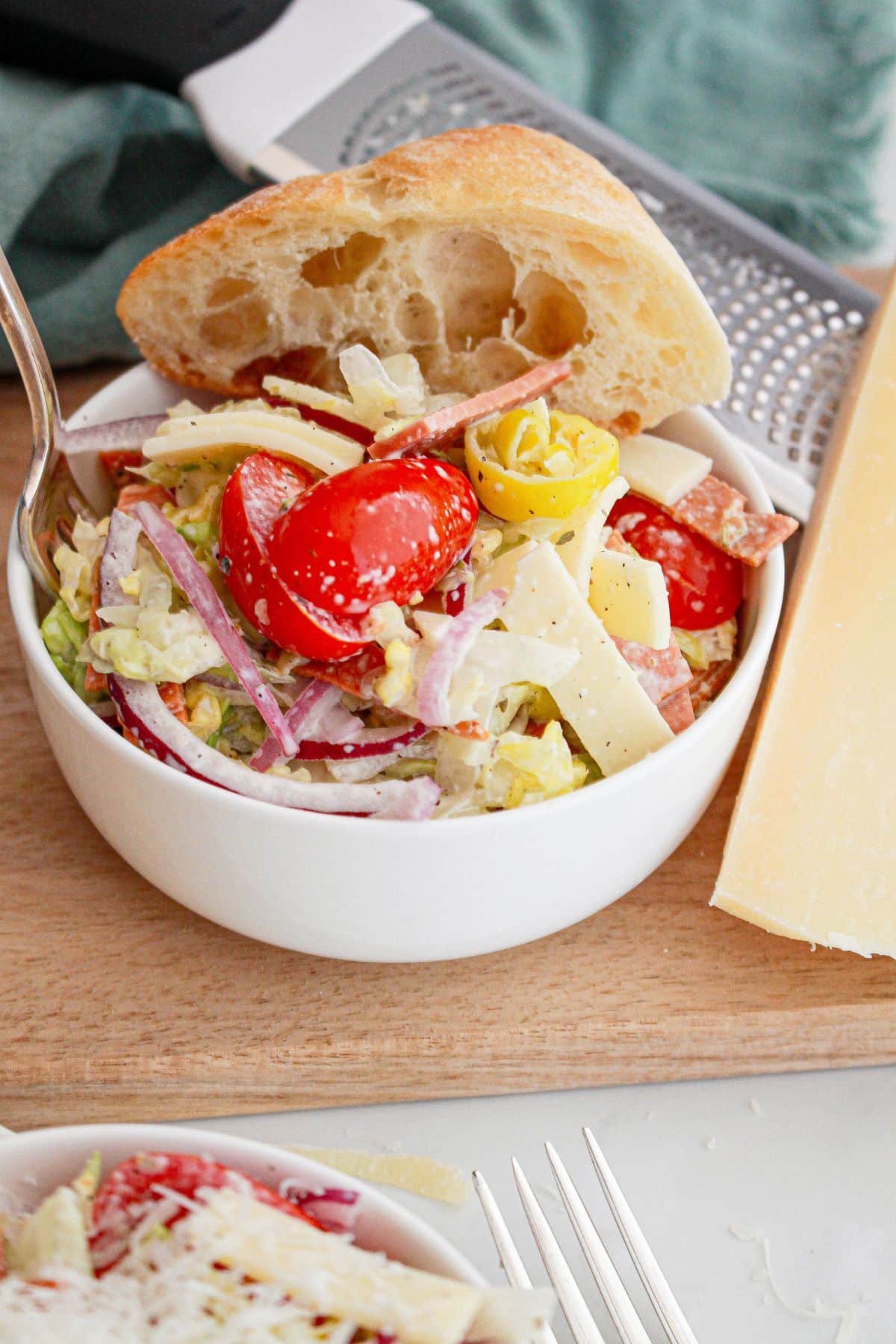 bowl full of grinder sub salad with a slice of french bread.