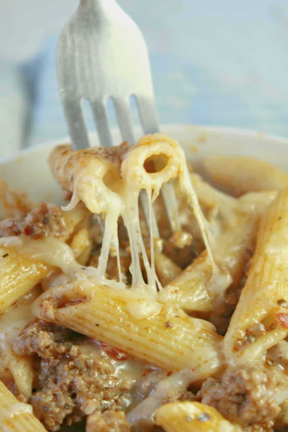 forkful of cheesy ground beef pasta skillet being removed from a bowl.