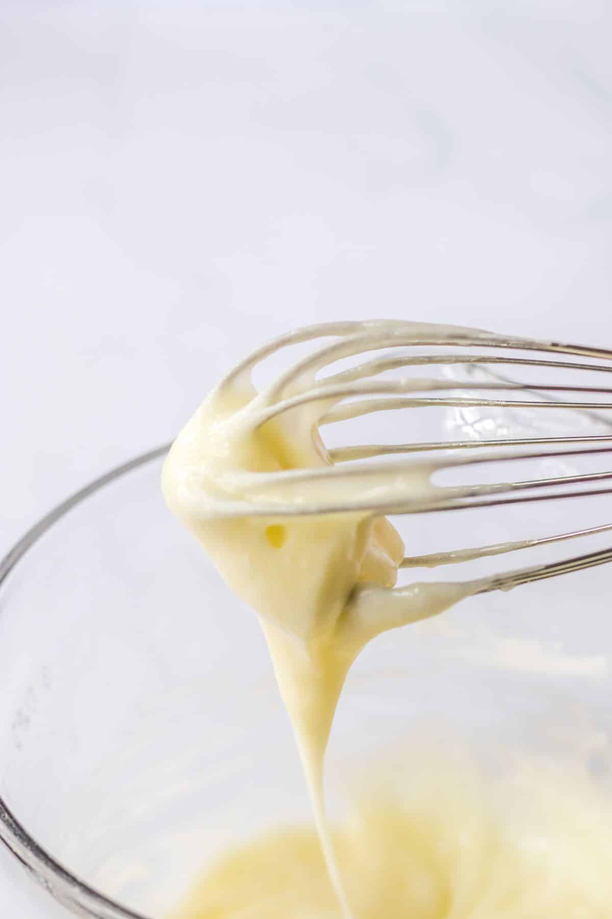 cream cheese frosting being made in a mixing bowl.