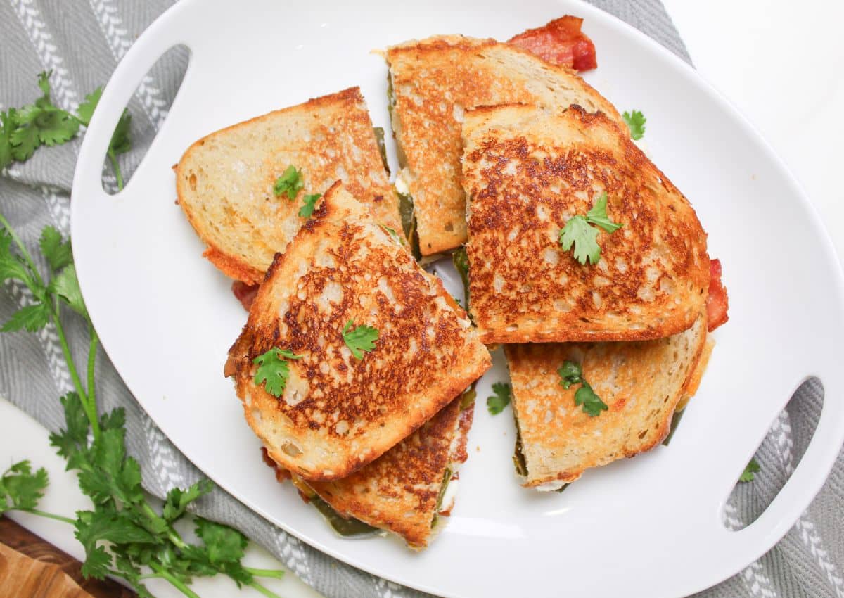 six halves of jalapeno popper grilled cheese sandwiches on a plate.