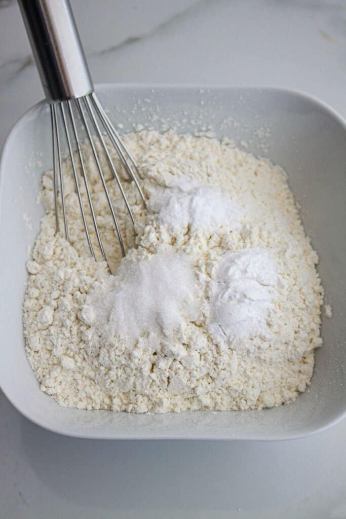 dry ingredients being mixed together with a whisk in a bowl.