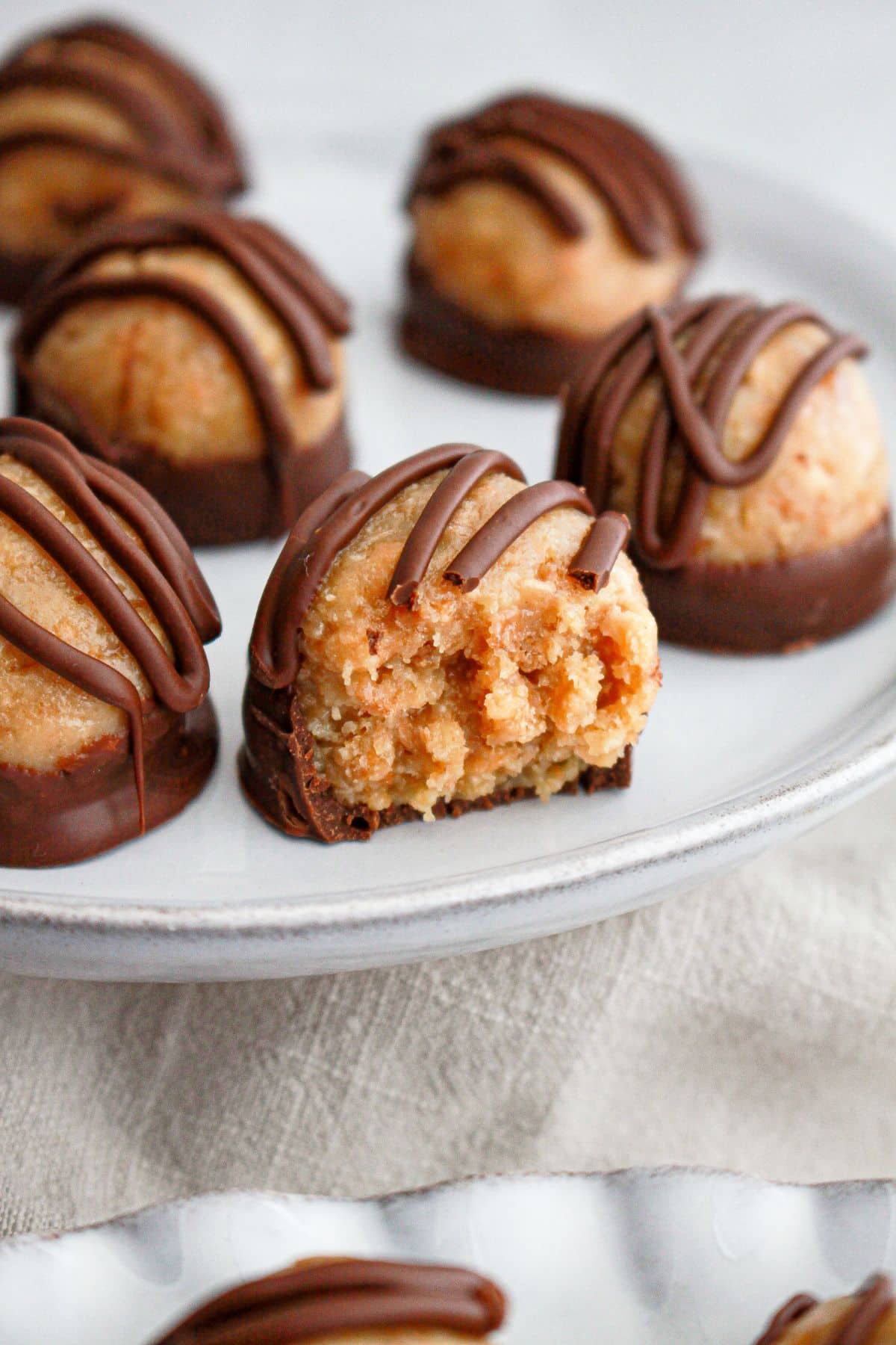 samon truffles on a serving plate, and one has a bite missing.