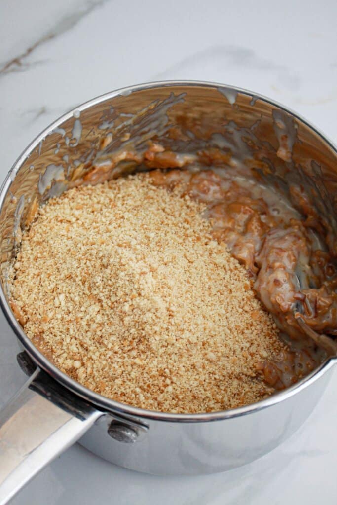 vanilla wafers being added to a caramel mixture.