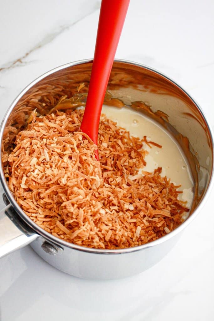 coconut being added to sweetened condensed milk.