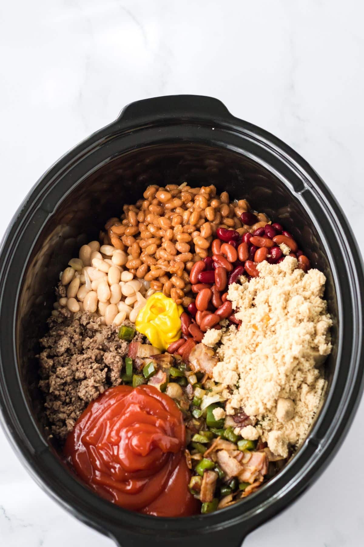 ingredients added to the slow cooker ready to be cooked.