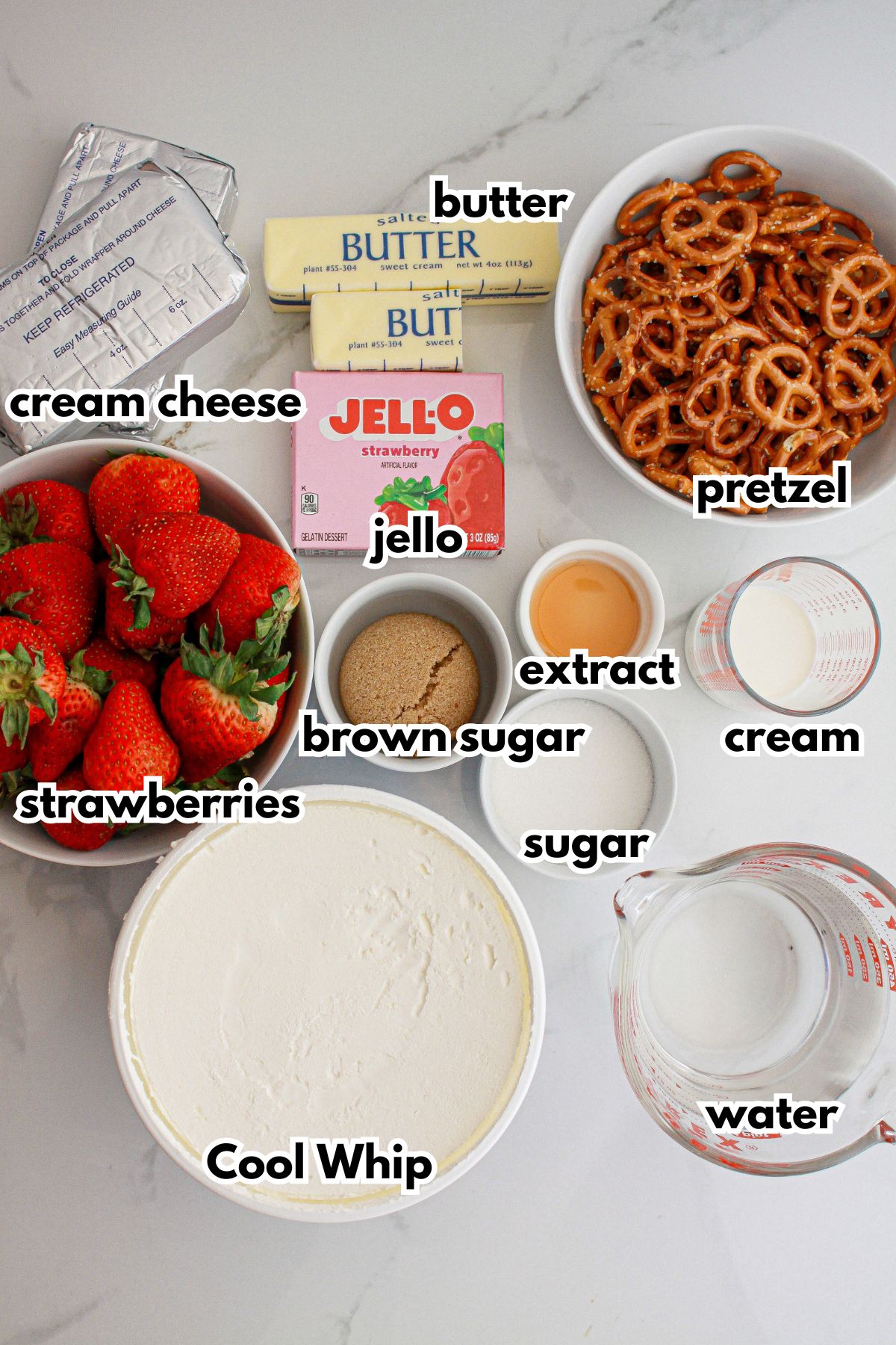 butter. cream cheese, strawberries, jello, pretzel, cool whip, brown sugar, extract, sugar, cream, and water on a counter.
