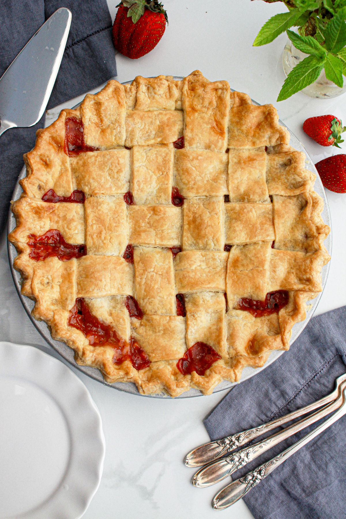 uncut strawberry rhubarb pie on a table.