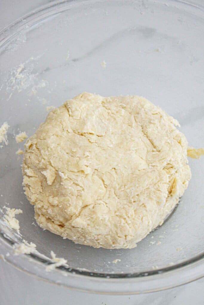 crust being mixed in a large glass mixing.