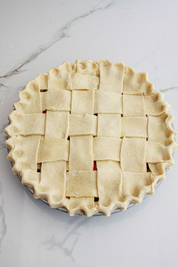 lattice crust being added to the top of the dessert.