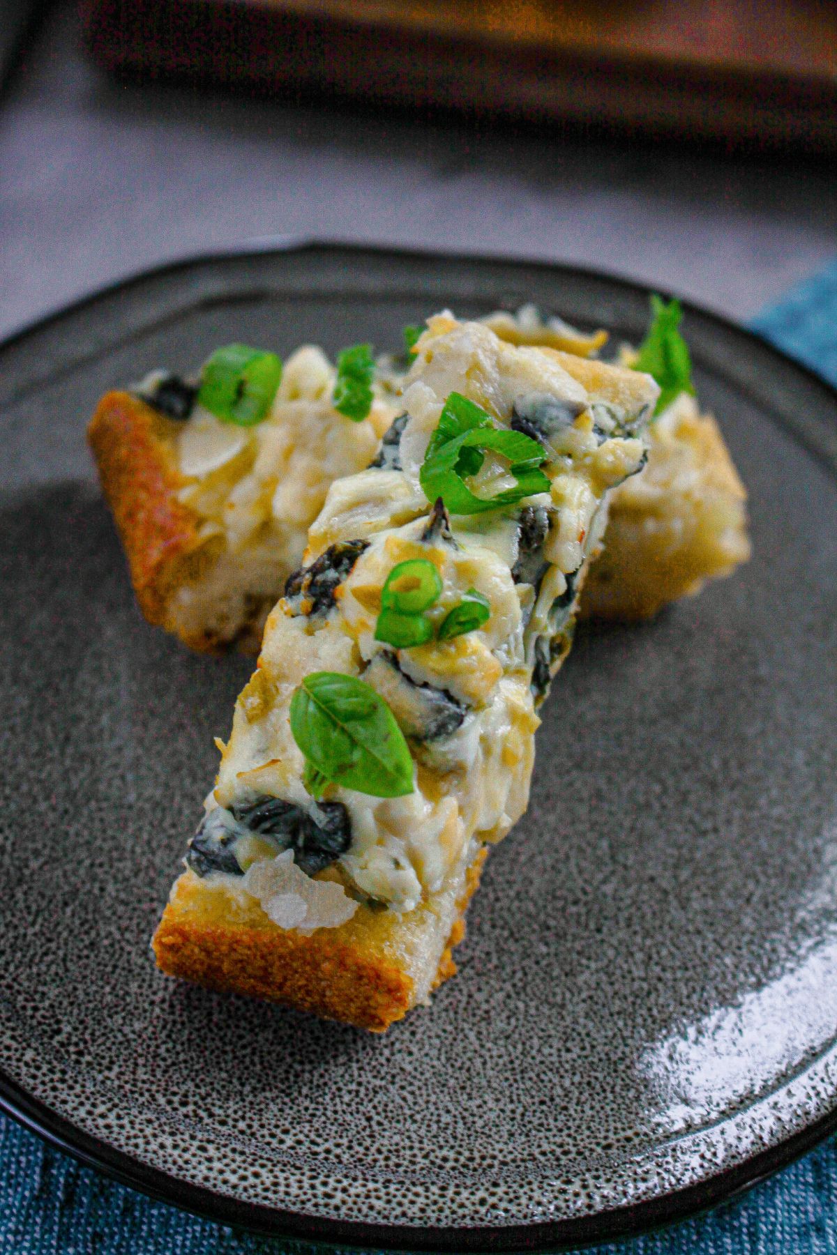 two slices of spinach artichoke stuffed garlic bread on a plate.
