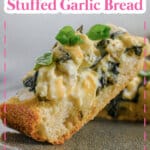 two slices of spinach artichoke stuffed garlic bread on a plate.