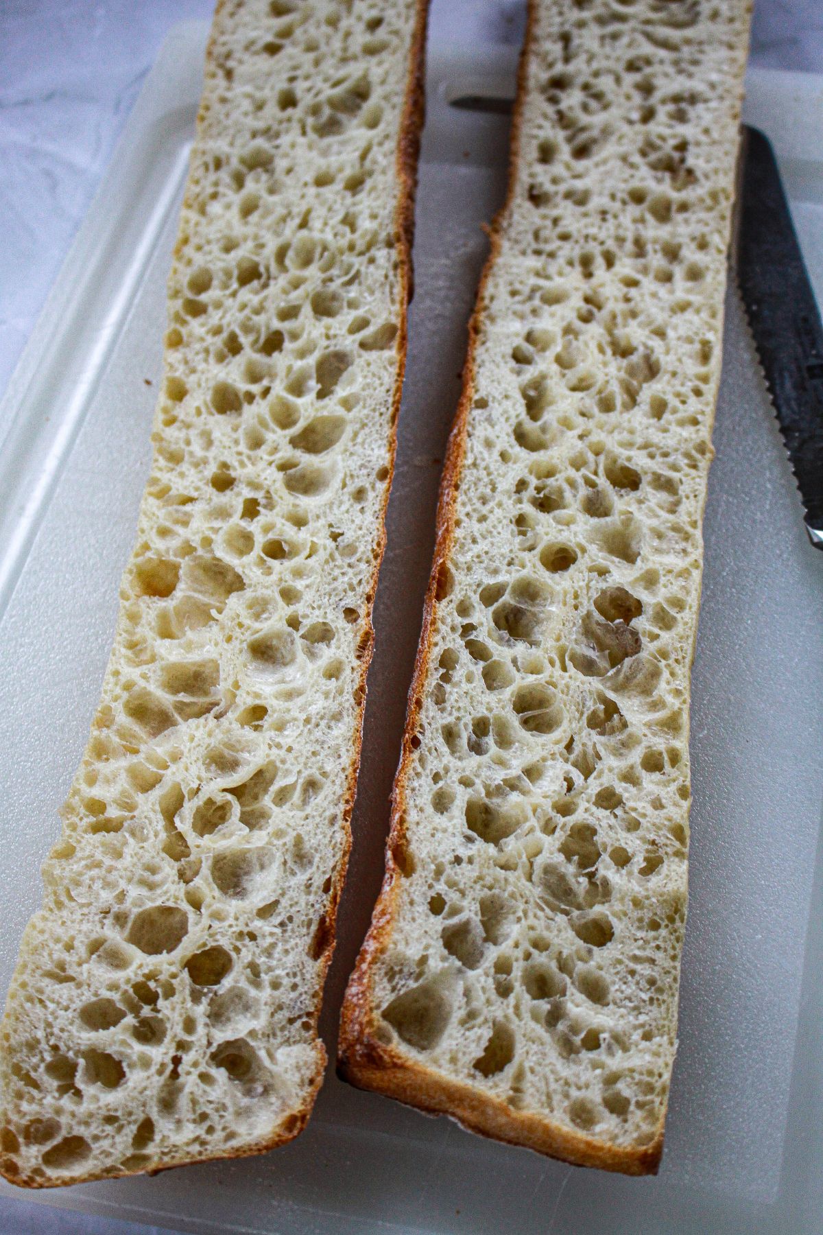 bagette being sliced open and ready for the the butter.